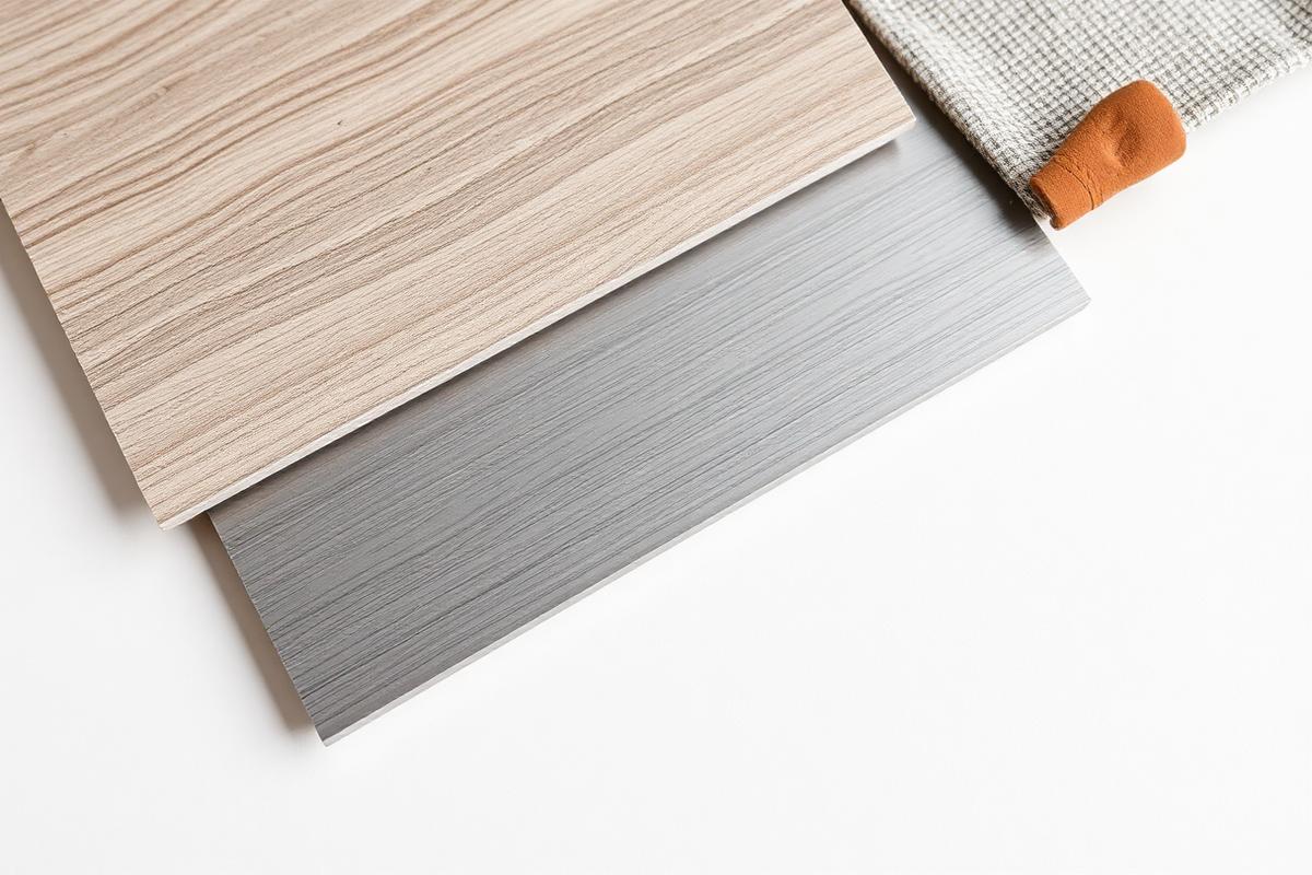 Materialmuster aus Holzfurnier, Steinoberfläche und Textil auf hellem Untergrund